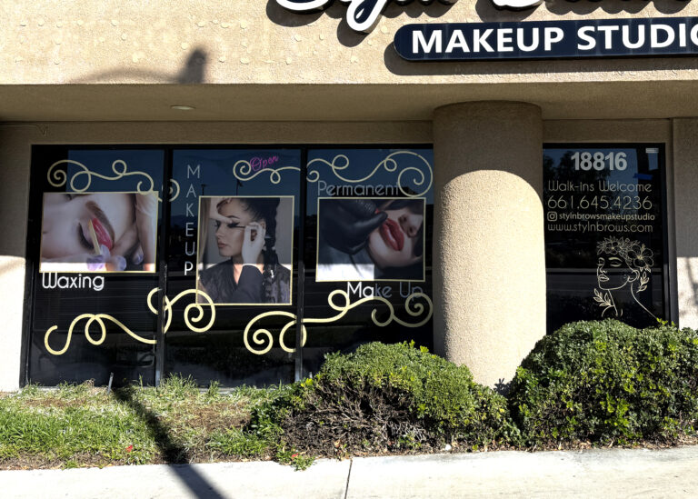 Custom window graphics and gold vinyl lettering for a makeup studio storefront