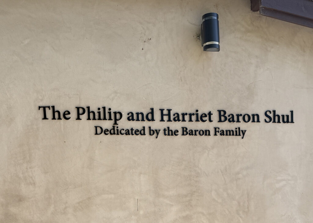 Black aluminum dimensional letters mounted on a stucco wall displaying a synagogue donor dedication sign.